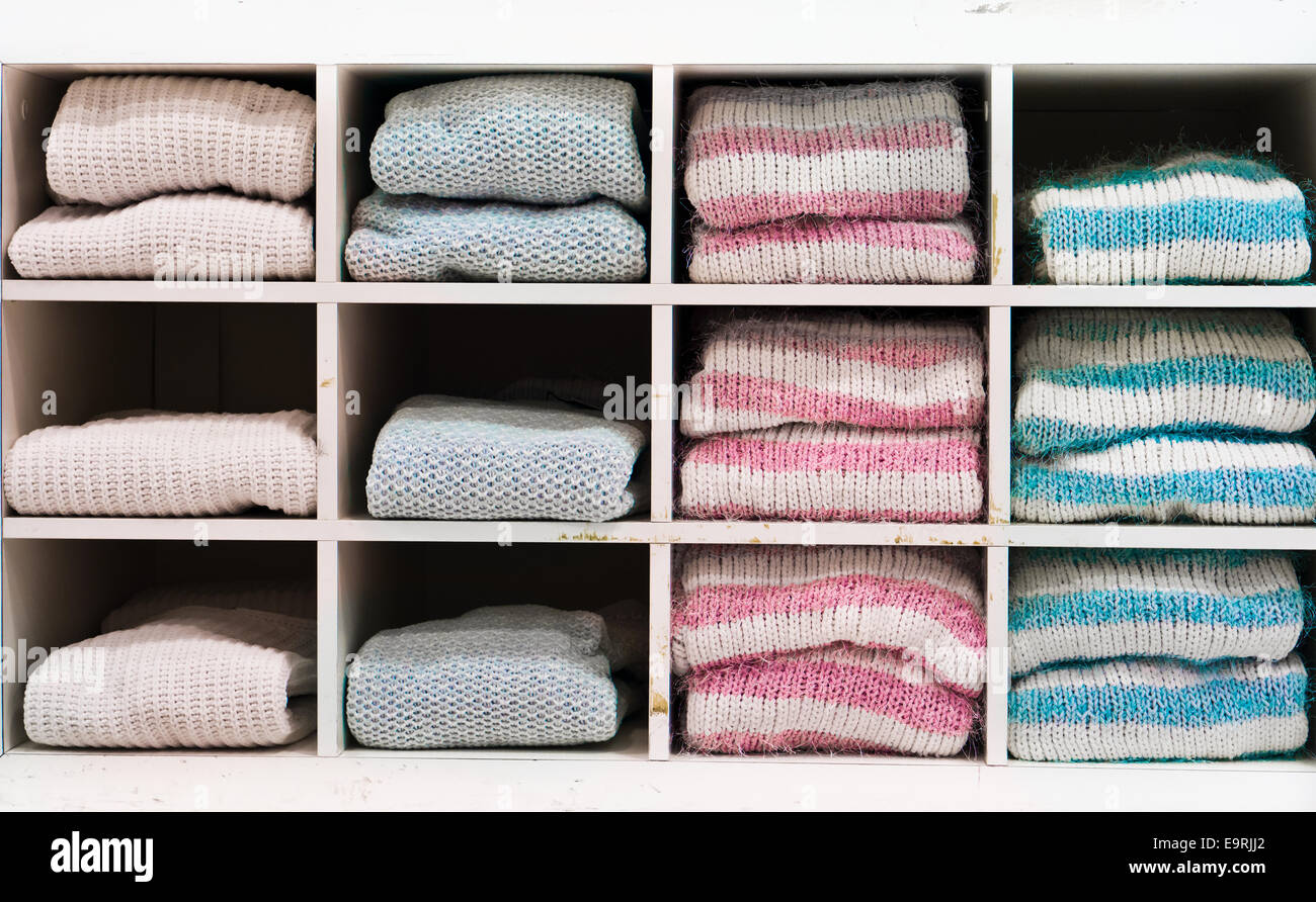 Selection of warm winter ladies' jumpers on a shelving unit Stock Photo