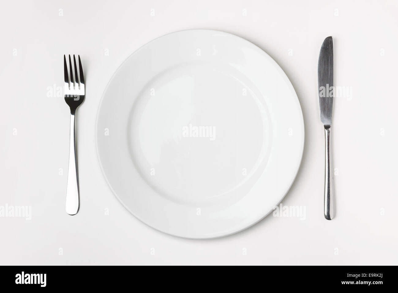 Knife, Fork and plate on table isolated Stock Photo - Alamy