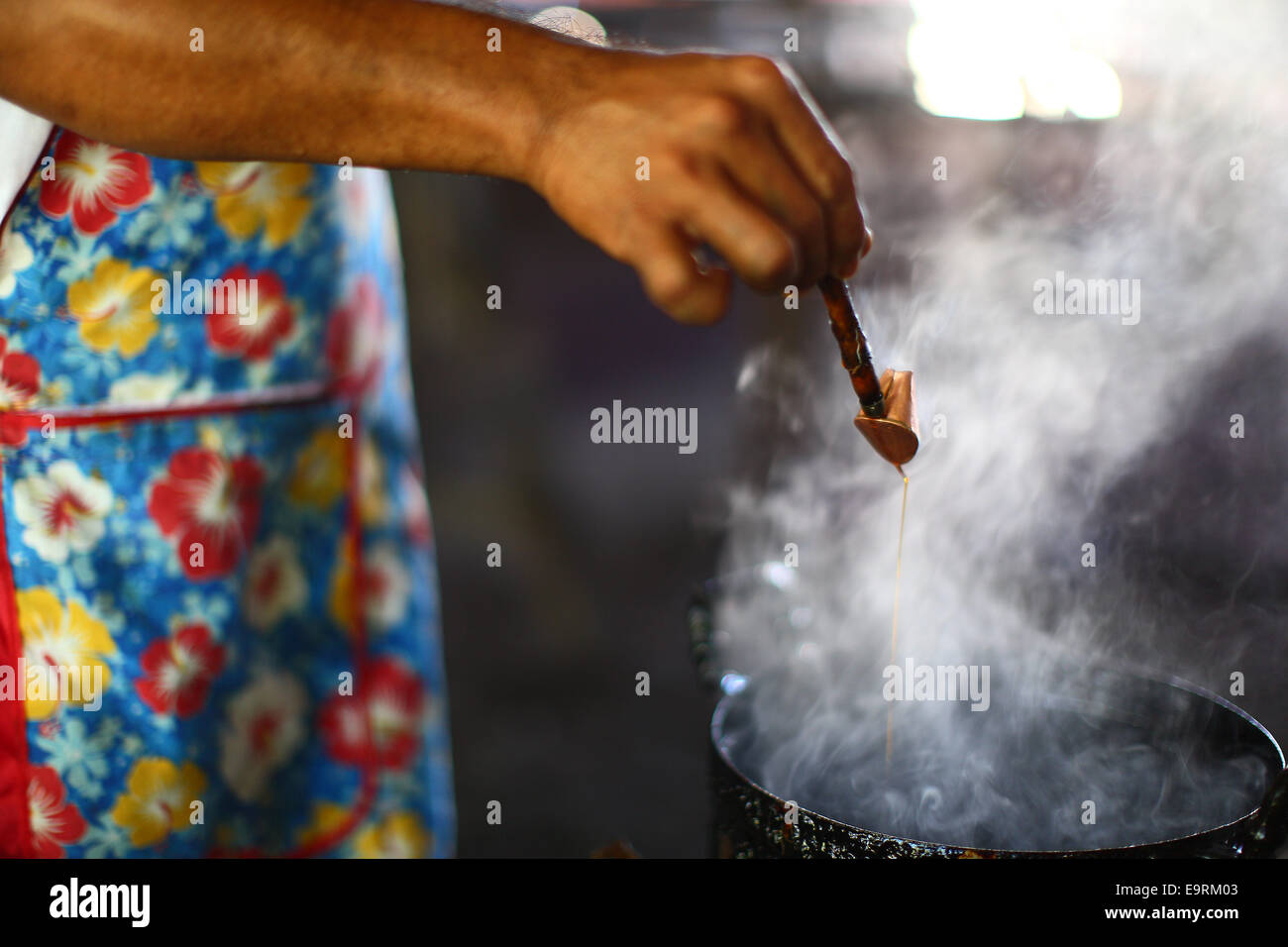 Preparing the melting wax for Batik Chanting traditional painting. Stock Photo