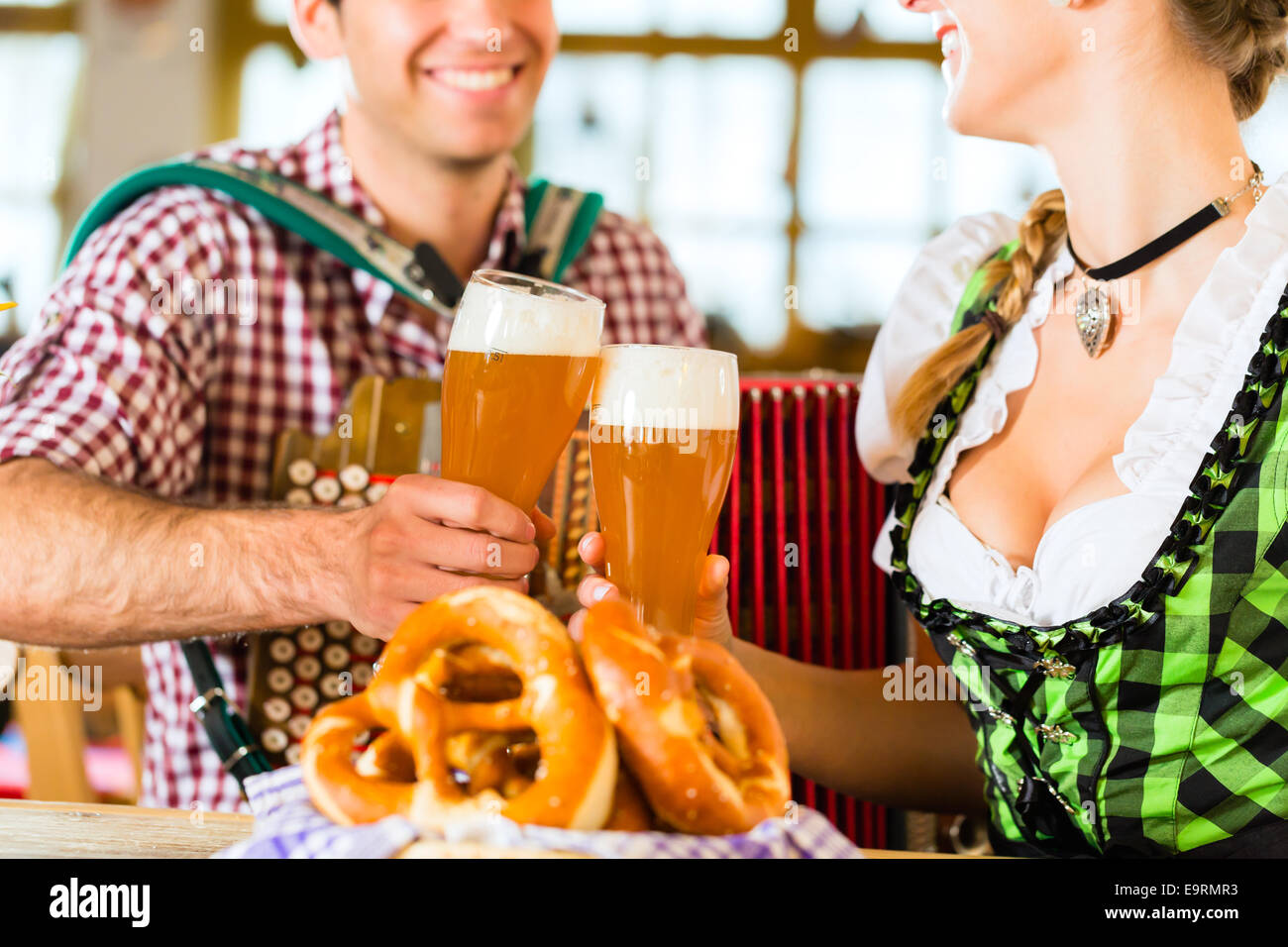 Bavarian restaurant with music, guests, wheat beer and pretzels Stock Photo
