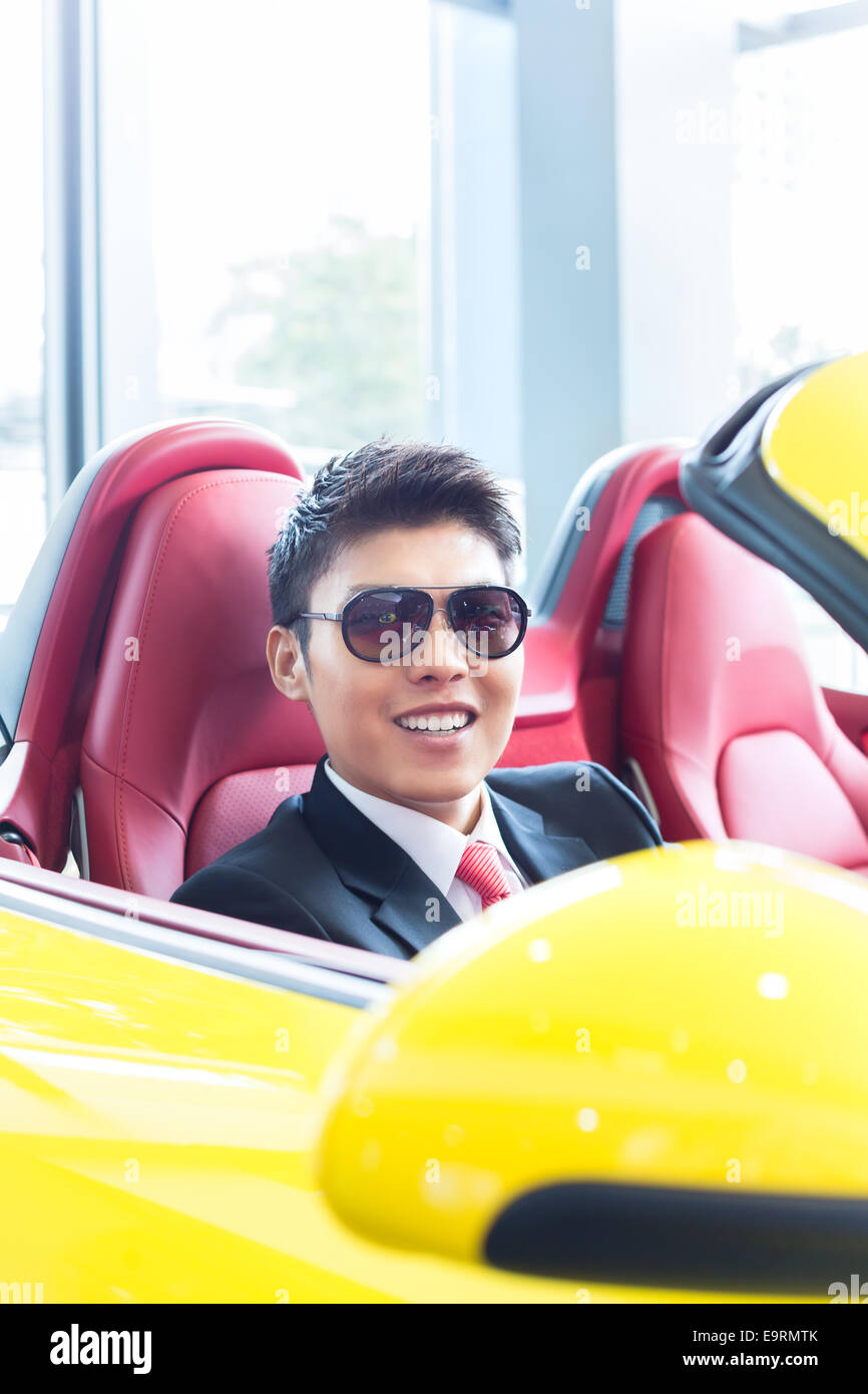 Asian man testing new sports car Stock Photo Alamy