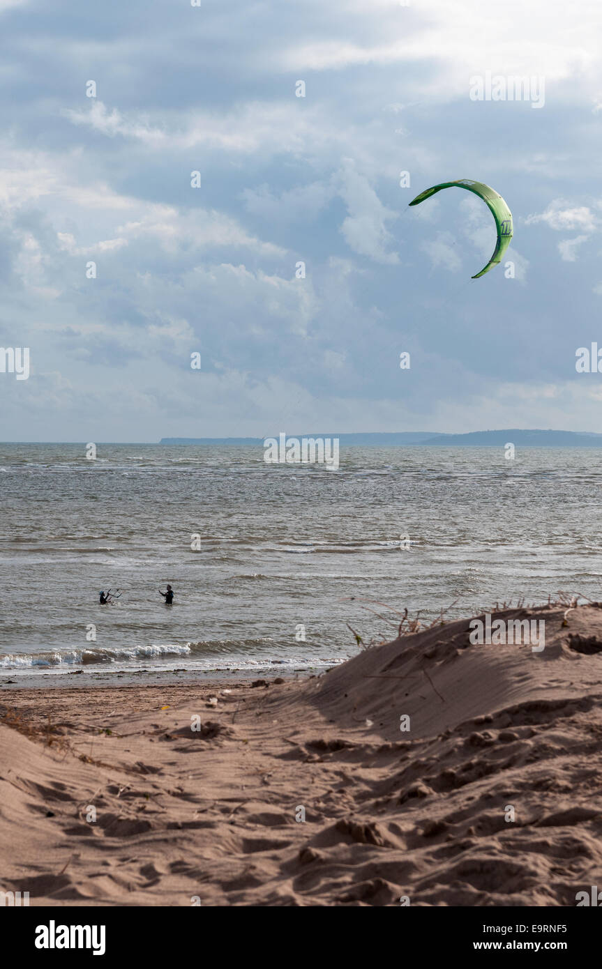 Male and female kite surfers on a windy day at Exmouth in Devon, UK. Good conditions for kite