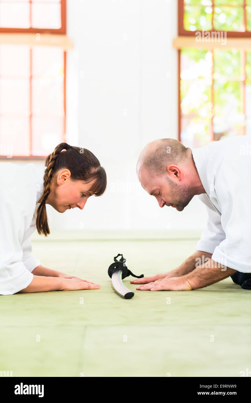Man and woman take a bow to greet at Aikido martial arts school Stock Photo