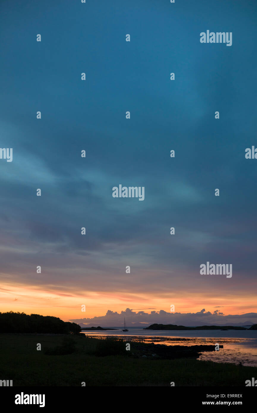 Skyscene of setting sun over Dunvegan Loch, the Isle of Skye in SCOTLAND Stock Photo