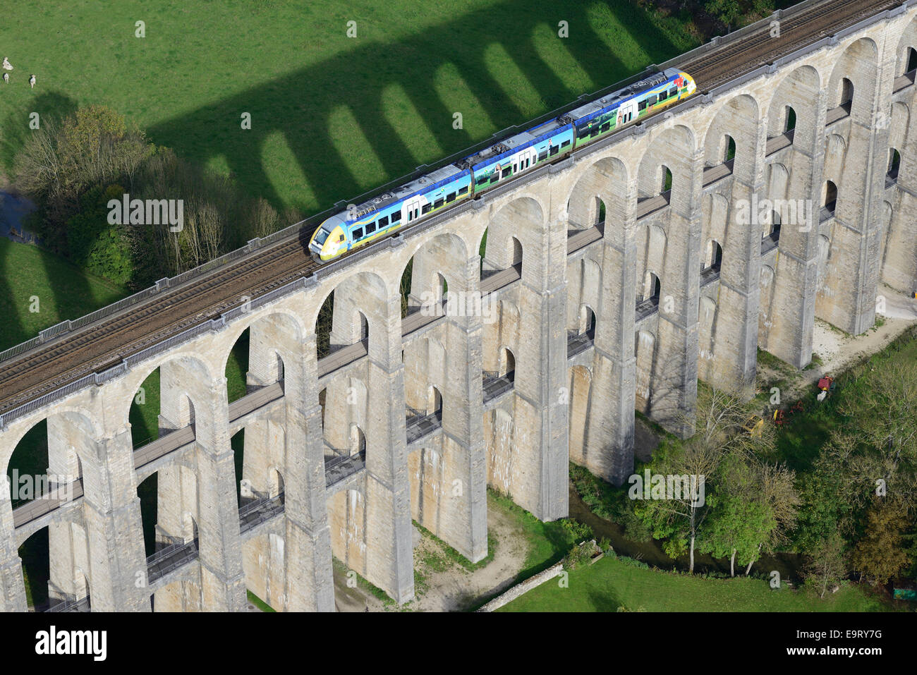 AERIAL VIEW. Commuter train on a historic (inaugurated in 1856) stone arch viaduct. Chaumont, Haute-Marne, Champagne-Ardenne, Grand Est, France. Stock Photo