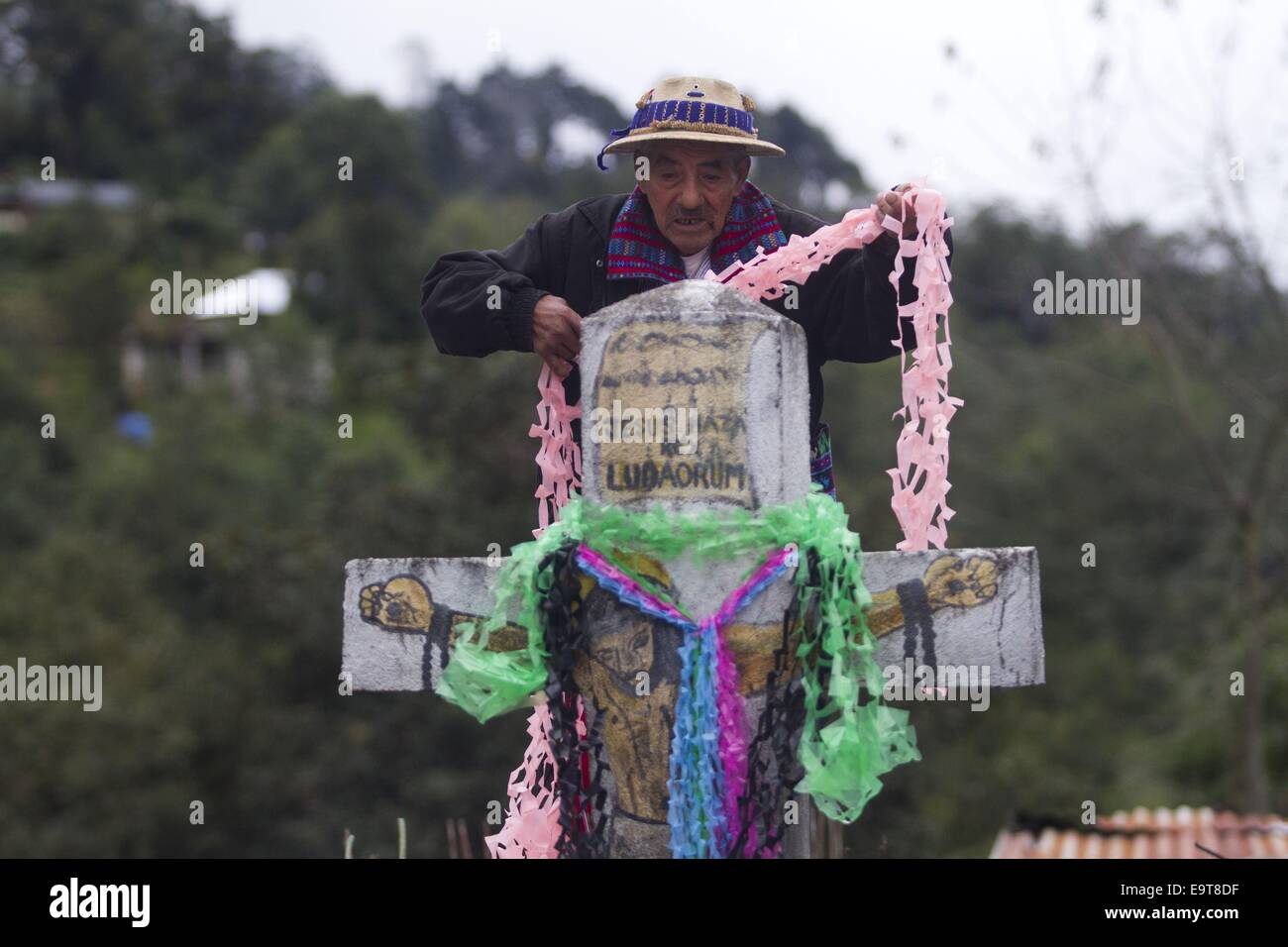 Huehuetenango, Guatemala. 1st Nov, 2014. A man decorates a grave during the commemoration of All Saints Day, in Todos Santos Cuchumatan municipality, Huehuetenango department, Guatemala, on Nov. 1, 2014. © Luis Echeverria/Xinhua/Alamy Live News Stock Photo