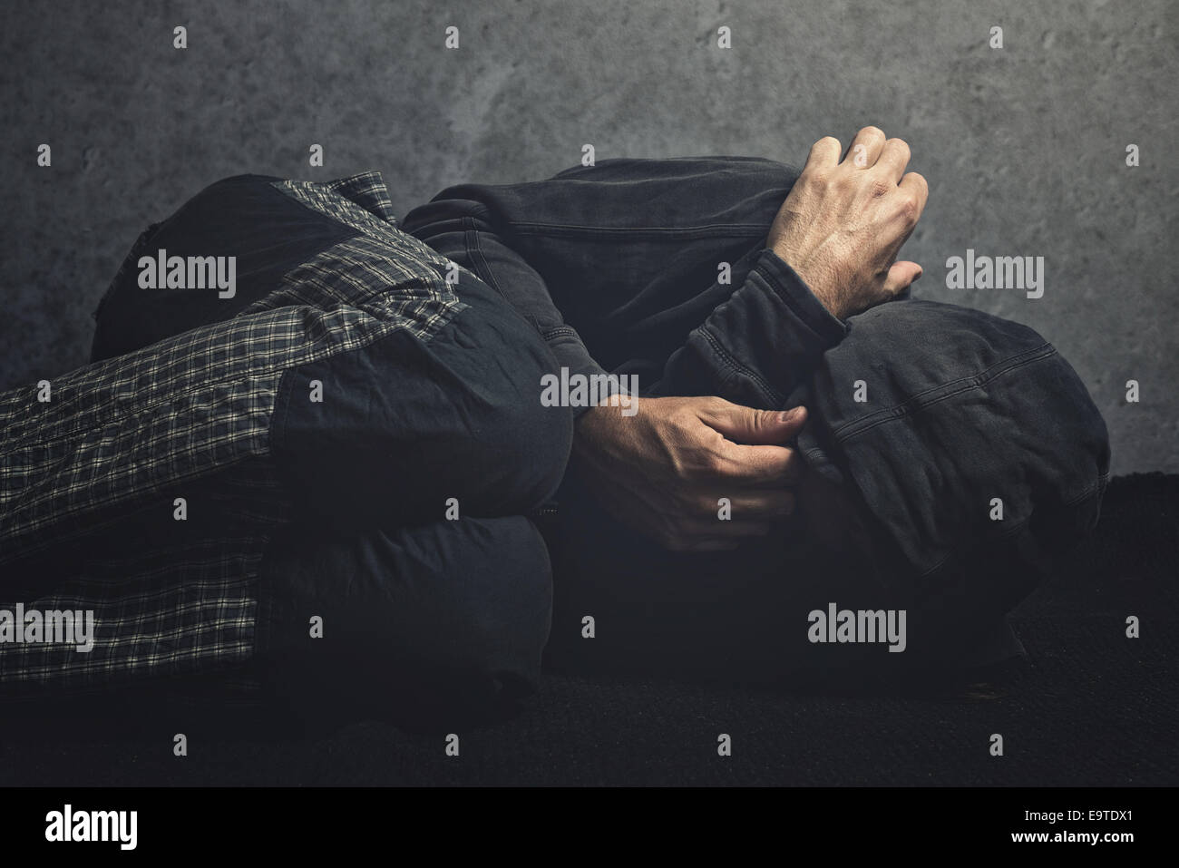 Drug Addict laying on the floor in agony, having an addiction crisis Stock Photo