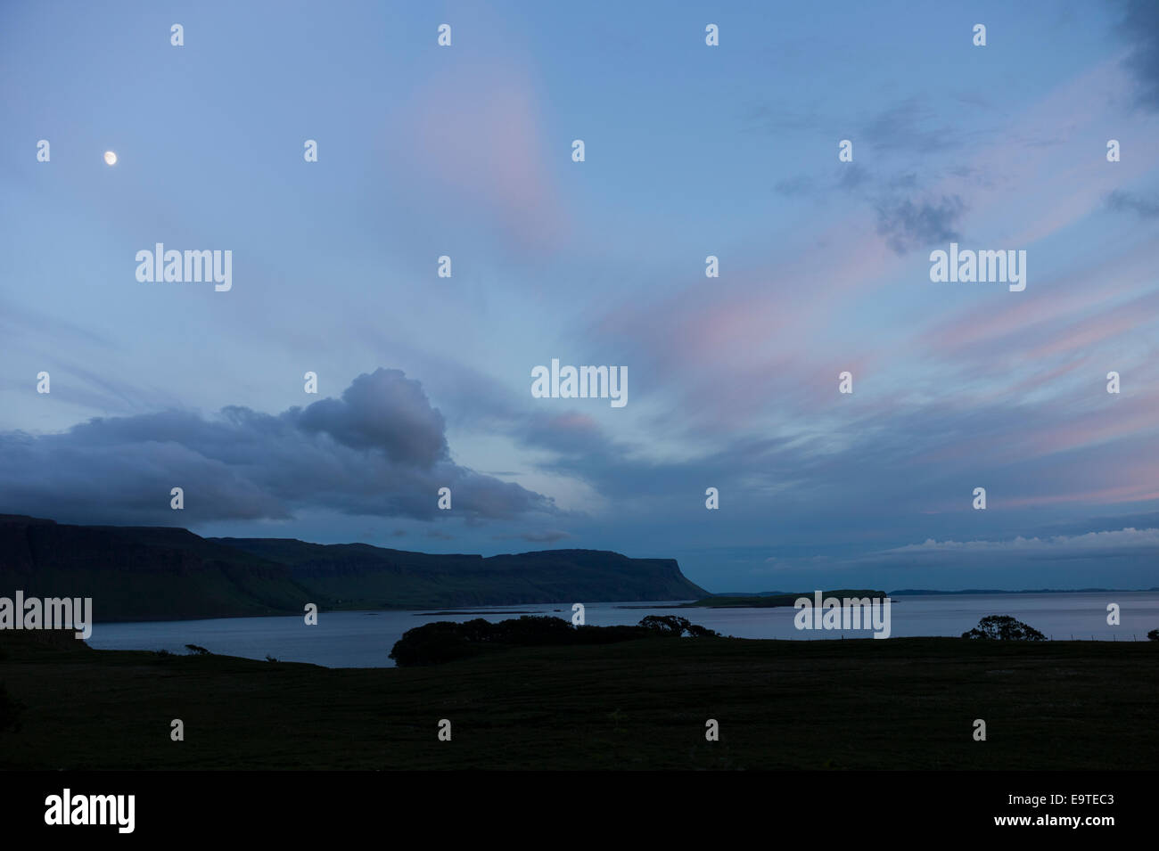 Panoramic sky scene view of pink and blue pastel colours and moon over Loch Na Keal at sunset on Isle of Mull, the Inner Hebride Stock Photo