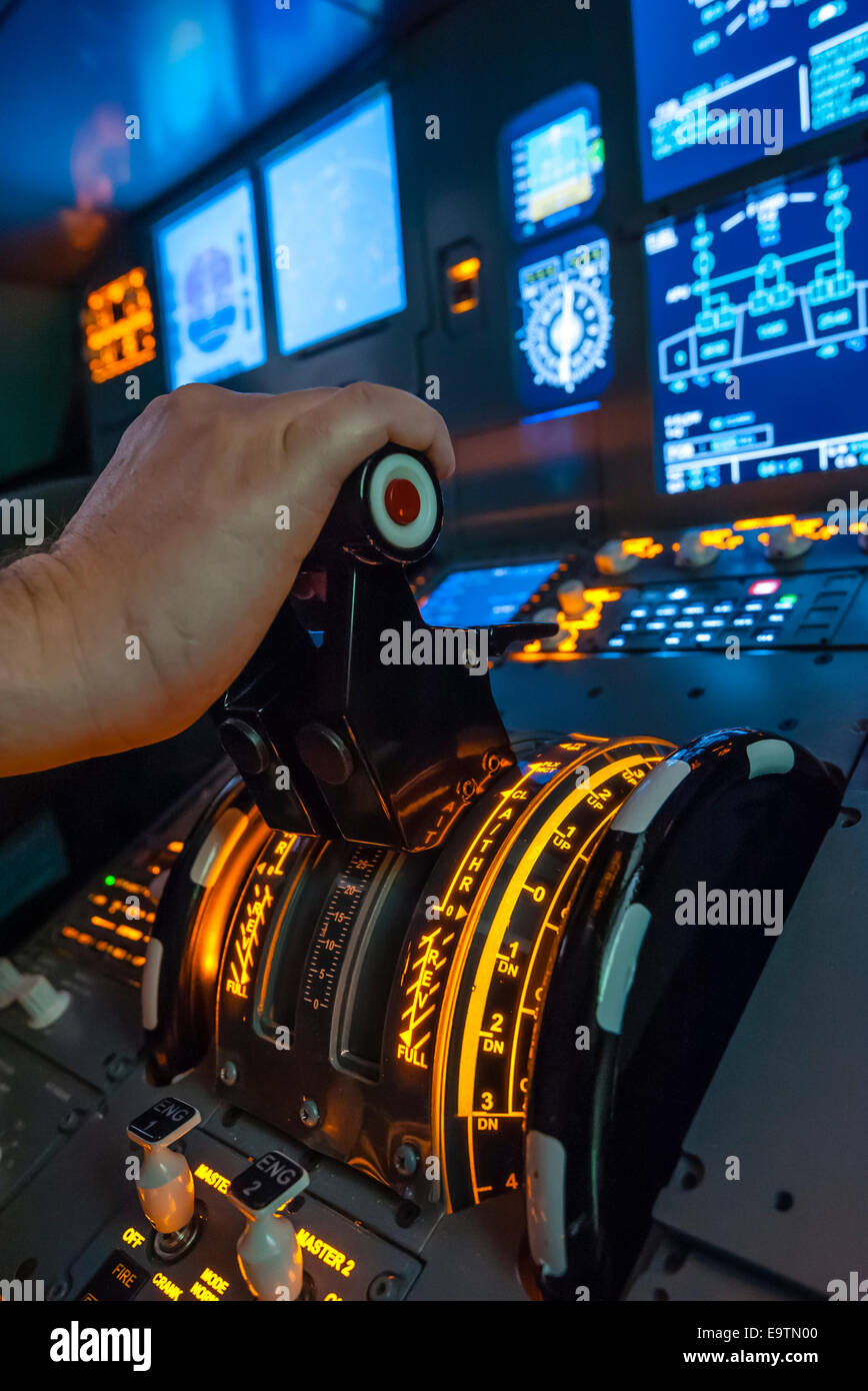 Cockpit of an Airbus A320 flight simulator that is used for training of professional airline pilots (hand on throttle lever). Stock Photo