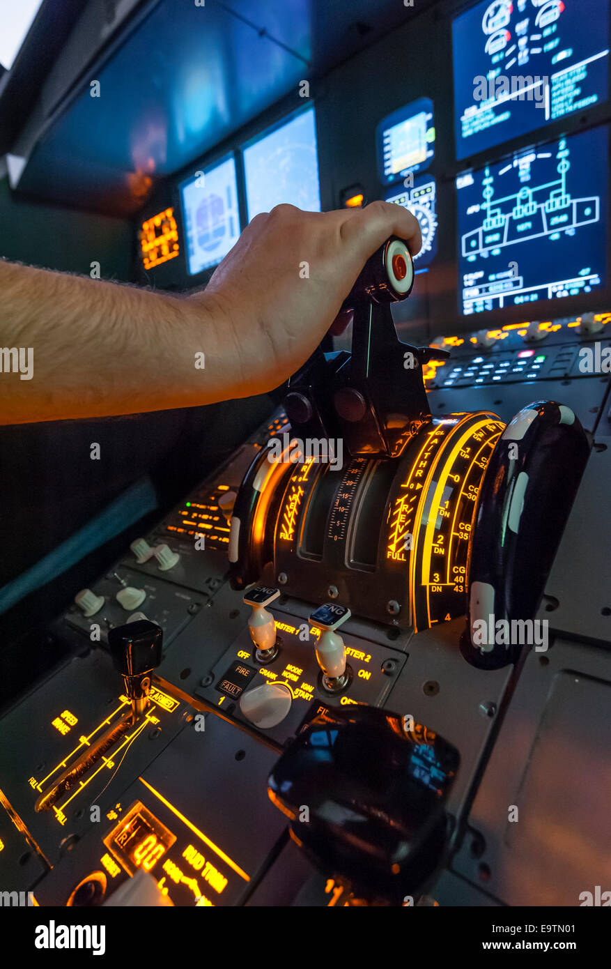 Cockpit of an Airbus A320 flight simulator that is used for training of professional airline pilots (hand on throttle lever). Stock Photo