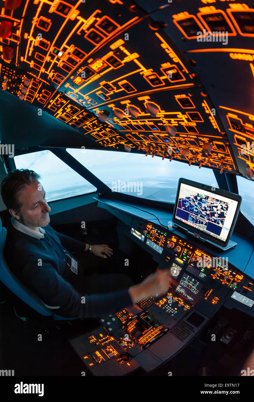 Cockpit of an Airbus A320 flight simulator that is used for training of professional airline pilots (pilot adjusting controls) Stock Photo