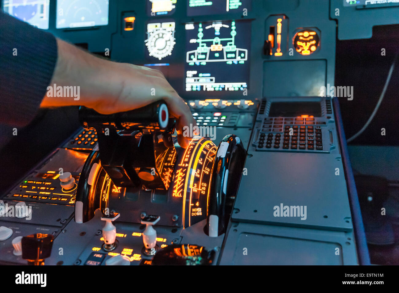 Cockpit of an Airbus A320 flight simulator that is used for training of professional airline pilots (hand on throttle lever) Stock Photo
