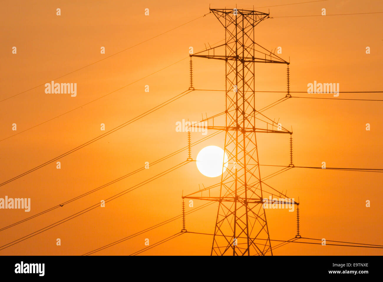 Silhouette of High voltage tower and the sun Stock Photo - Alamy