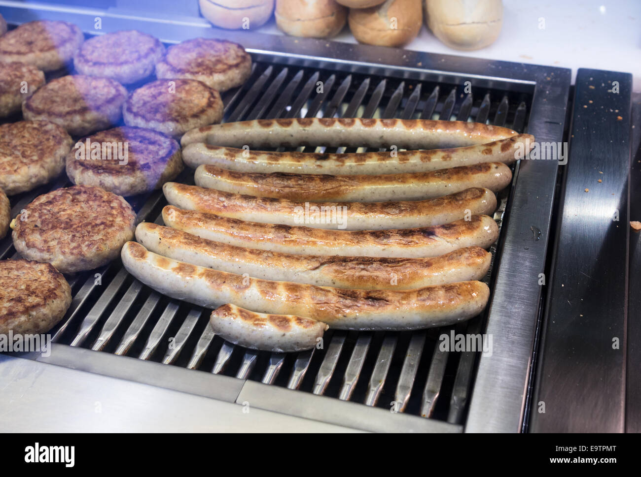 Currywurst and burger patties being cooked, prepared foods counter, Germany Stock Photo