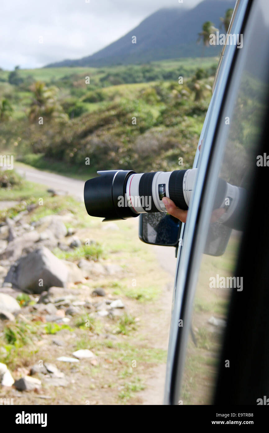 Paparazzi hiding in a car with long lens to take pictures. Stock Photo