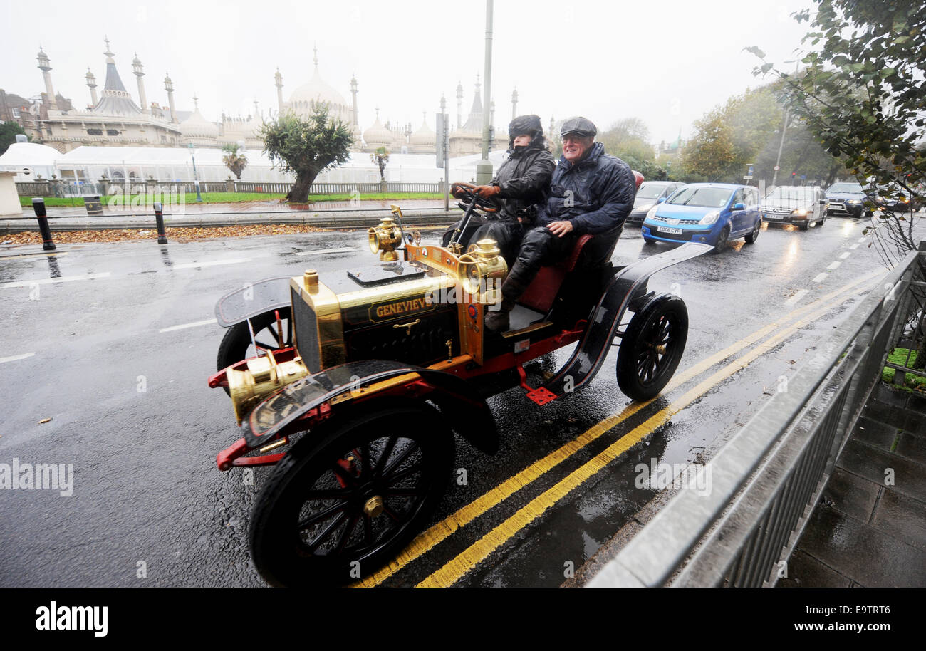 Brighton, UK. 02nd Nov, 2014. Drivers and their passengers in the famous Genevieve car brave the dreadful wet and windy weather as they arrive in Brighton at the end of the journey at the Bonhams London to Brighton Veteran Car Run today The Run takes place on the first Sunday of every November and is the longest running motoring event in the world Genevieve became well known from the 1953 British film of the same name and is a 1904 Darracq 12hp. Credit:  Simon Dack/Alamy Live News Stock Photo