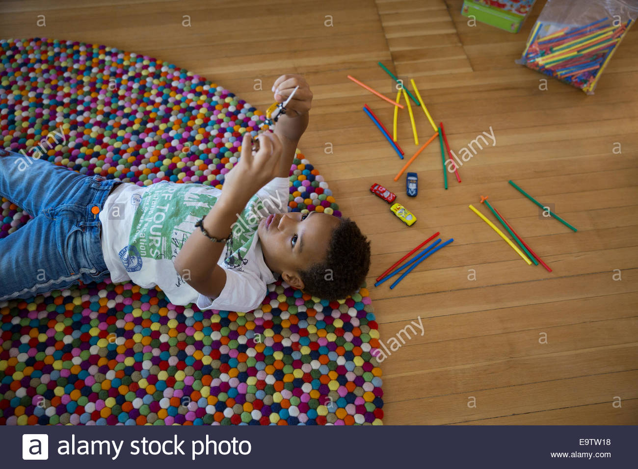 Boy using cell phone upsidedown on rug Stock Photo Alamy