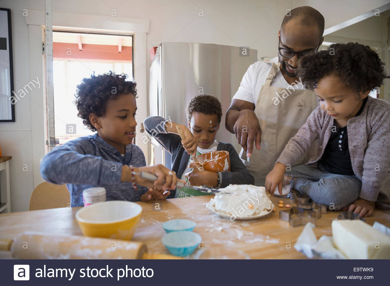 Father and children baking cake in kitchen Stock Photo