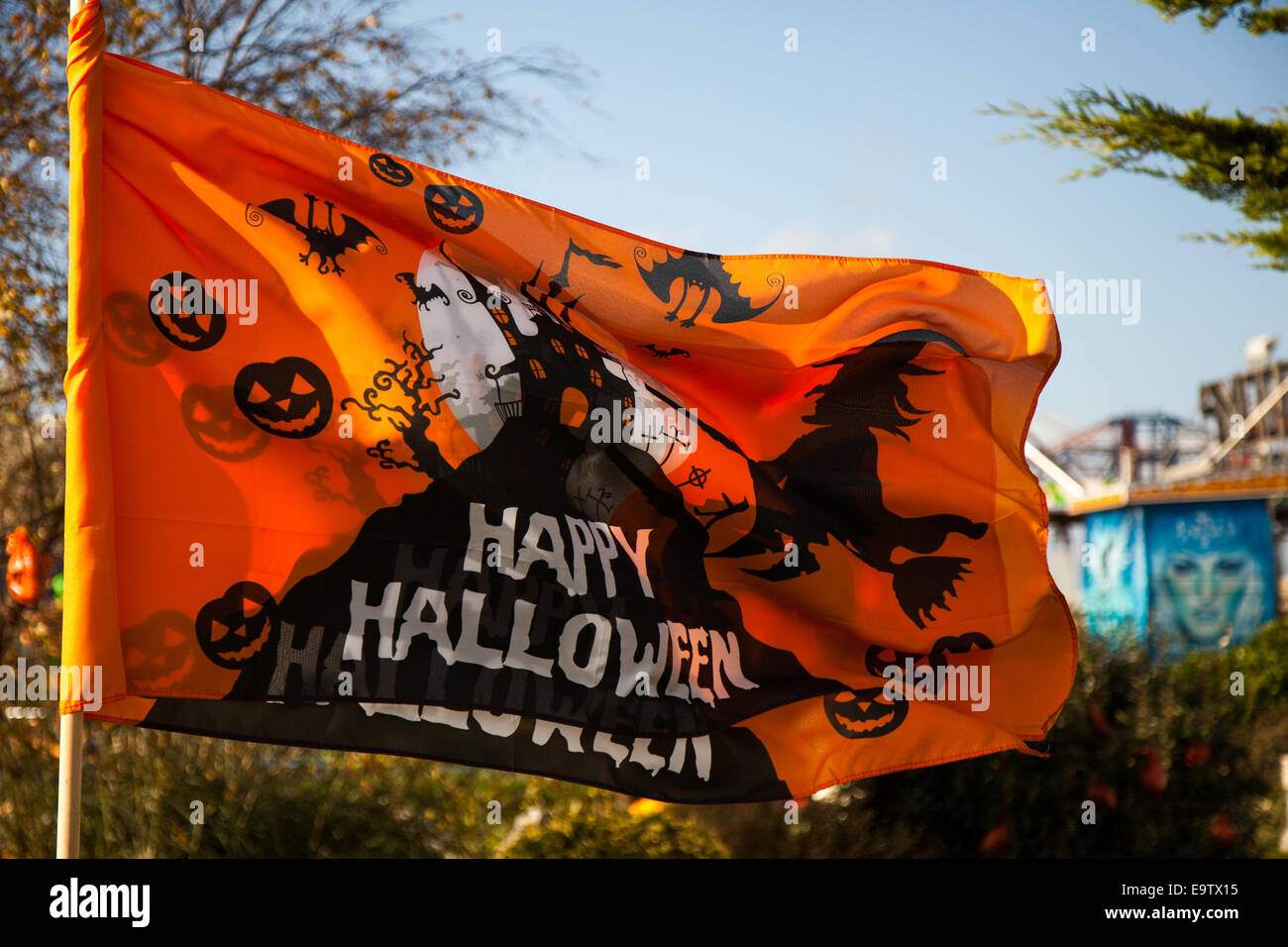 Orange Happy Halloween Flag flying at Pleasureland, Southport  The last day of opening for the 2014 season saw a myriad of characters greeting visitors.  A day dedicated to fun stuff, ghastly ghosts, weird witches, wonky wizards, beastly bats and more pumpkins that you can poke a broomstick, few strange scarecrows, and silly skeletons. Stock Photo