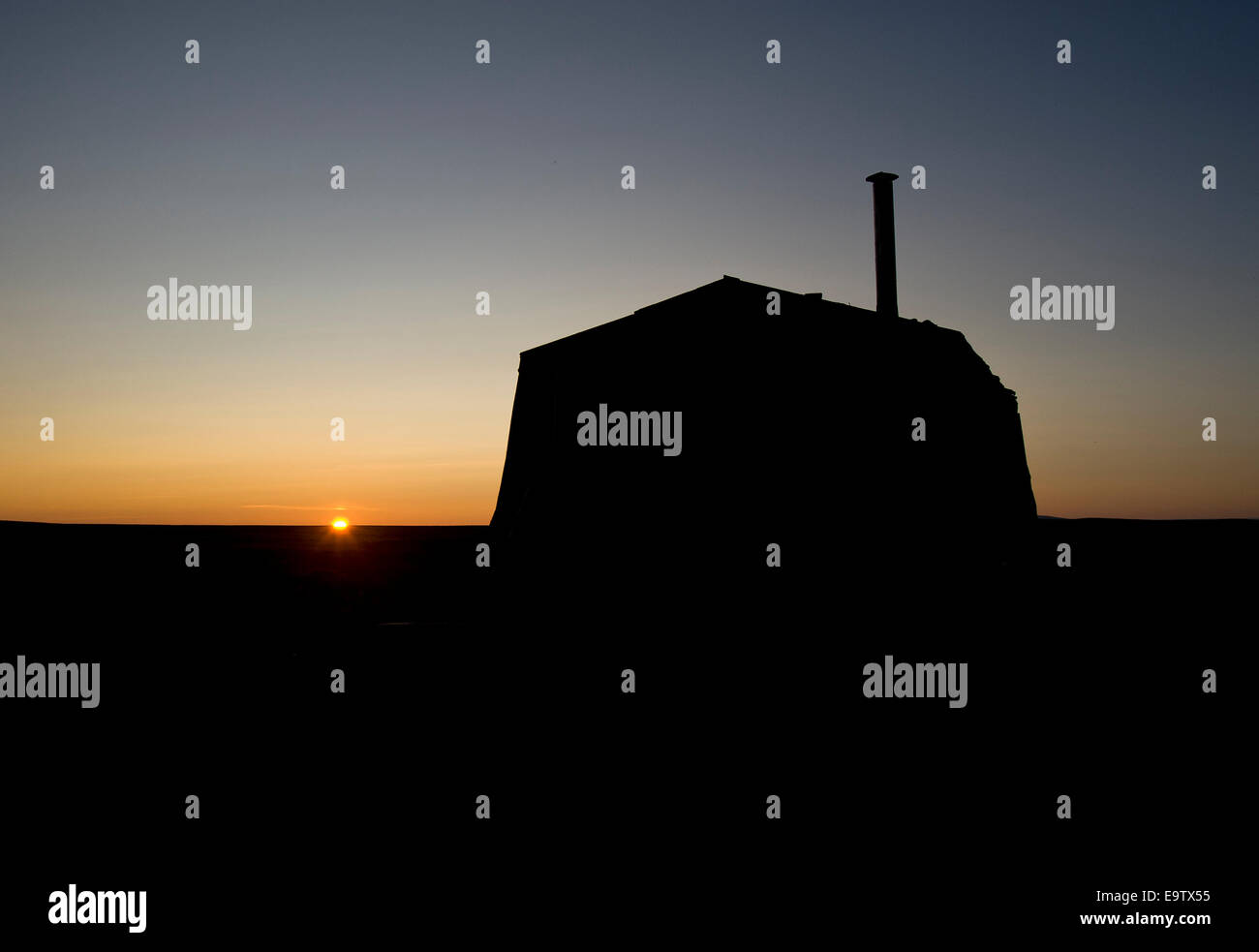 Silhouette of wilderness hut at sunset Stock Photo