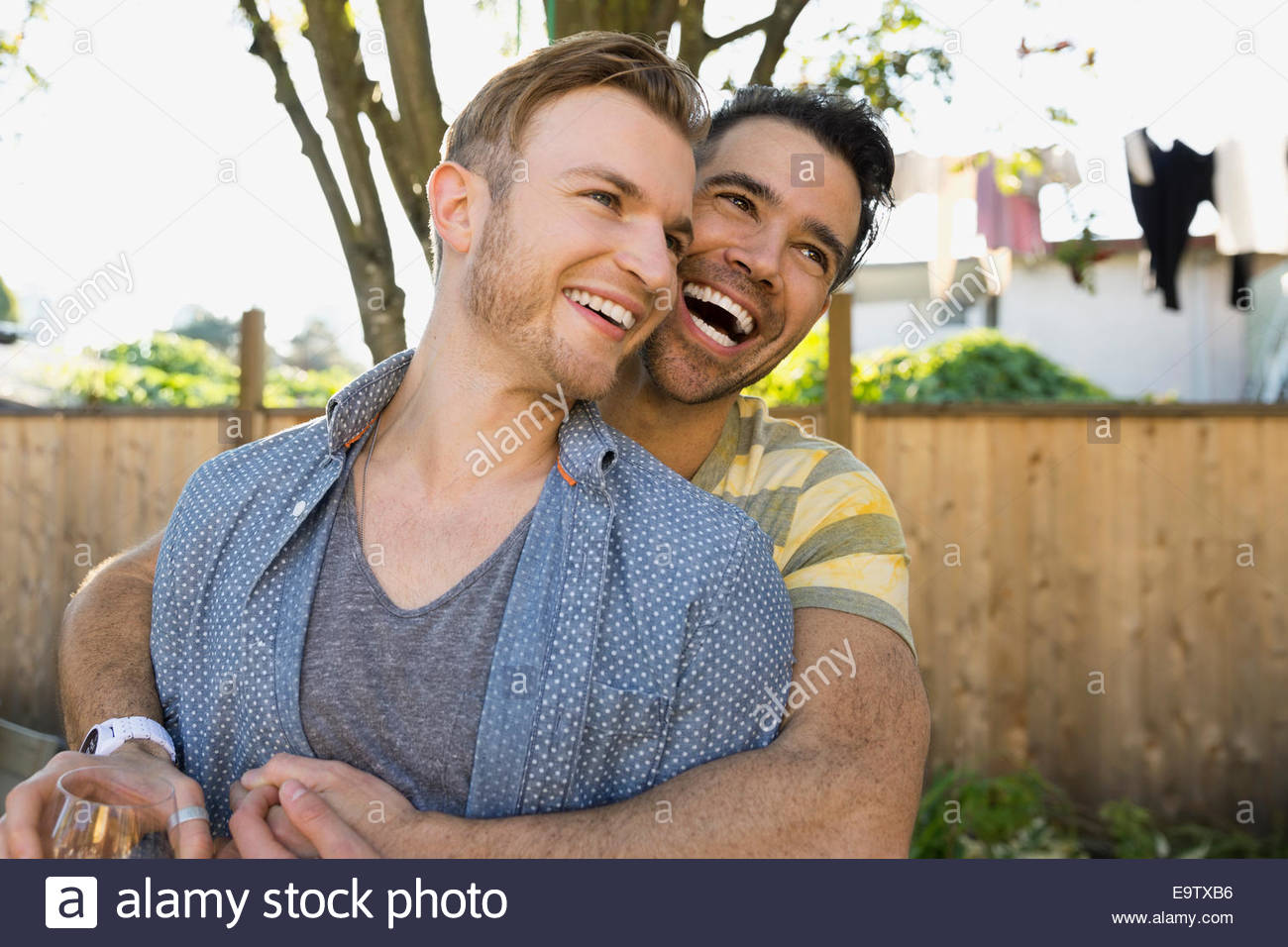 Homosexual couple hugging in backyard Stock Photo