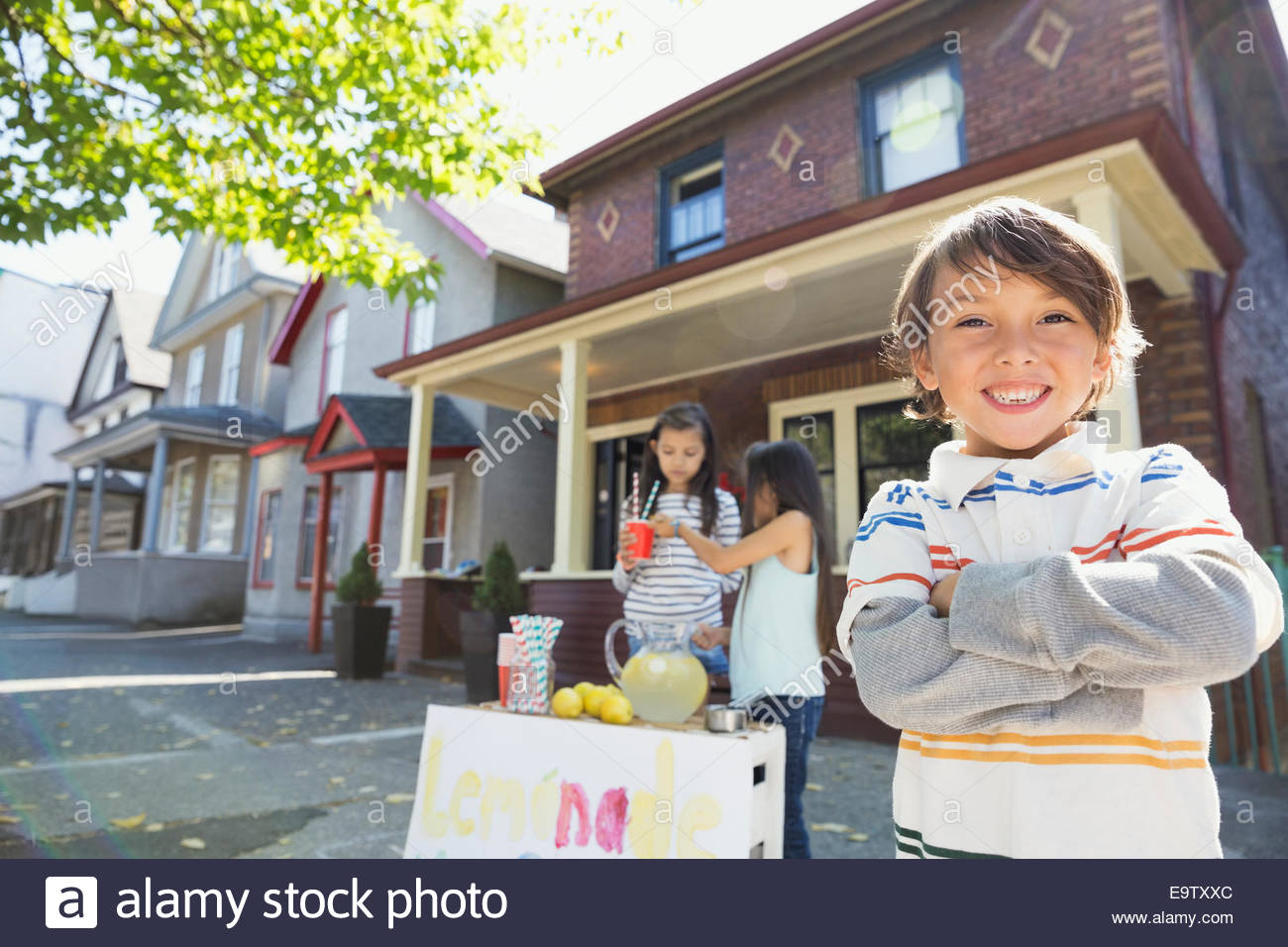 A 5-year old boy sits at a lemonade stand with cups and a pitcher of  lemonade Stock Photo - Alamy