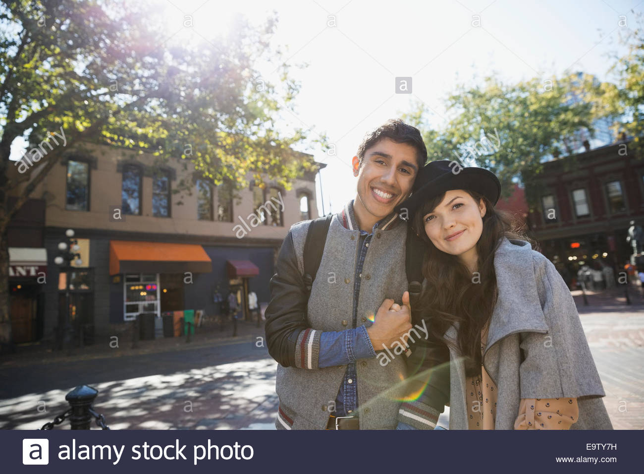 Smiling couple holding hands on sunny urban street Stock Photo - Alamy