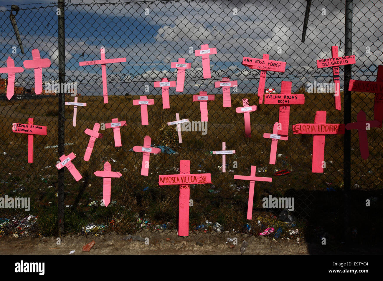 EL ALTO, BOLIVIA, 2nd November 2014. Crosses with the names of women on a wire mesh fence, part of a memorial for recent victims of femicide and domestic violence against women. According to a WHO report in January 2013 Bolivia is the country with the highest rate of violence against women in Latin America. Credit:  James Brunker / Alamy Live News Stock Photo