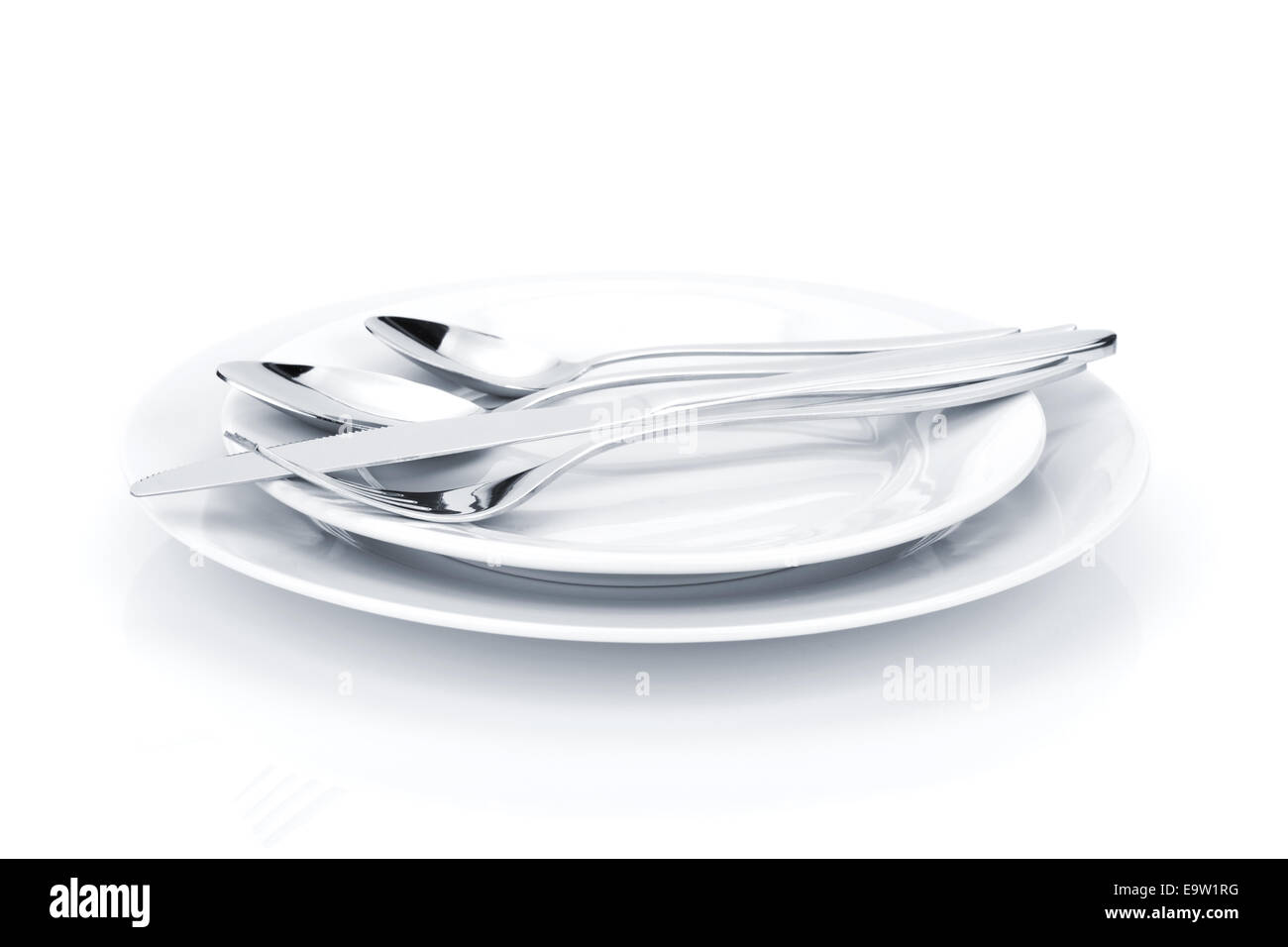 Silverware or flatware set over plates. Isolated on white background