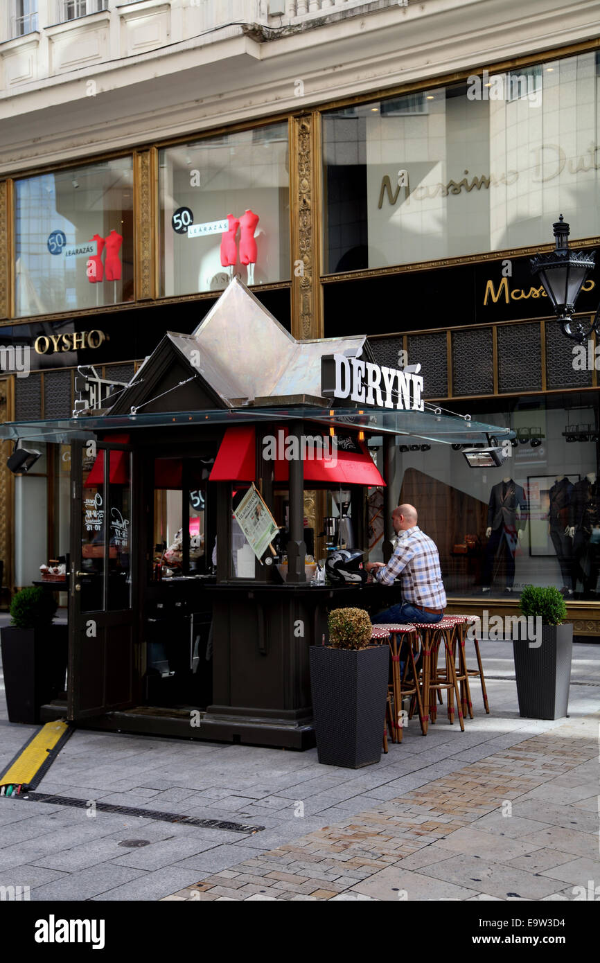 Man sitting at kiosk or bistro on street in Budapest Hungary with drink Stock Photo