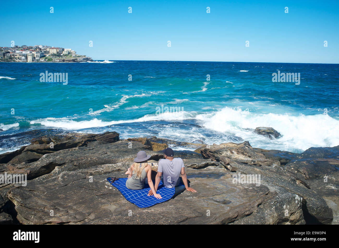 A picnicking couple looking out on the Pacific Ocean at Bondi, New South Wales, Australia Stock Photo
