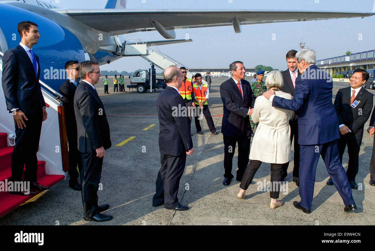 U.S. Secretary of State John Kerry hugs Peace Corps Director Carolyn Hessler-Radelet as she and the rest of a delegation representing President Obama are introduced to Indonesian Ministry of Foreign Affairs Ambassador Dian Triansyah Djani upon their arriv Stock Photo