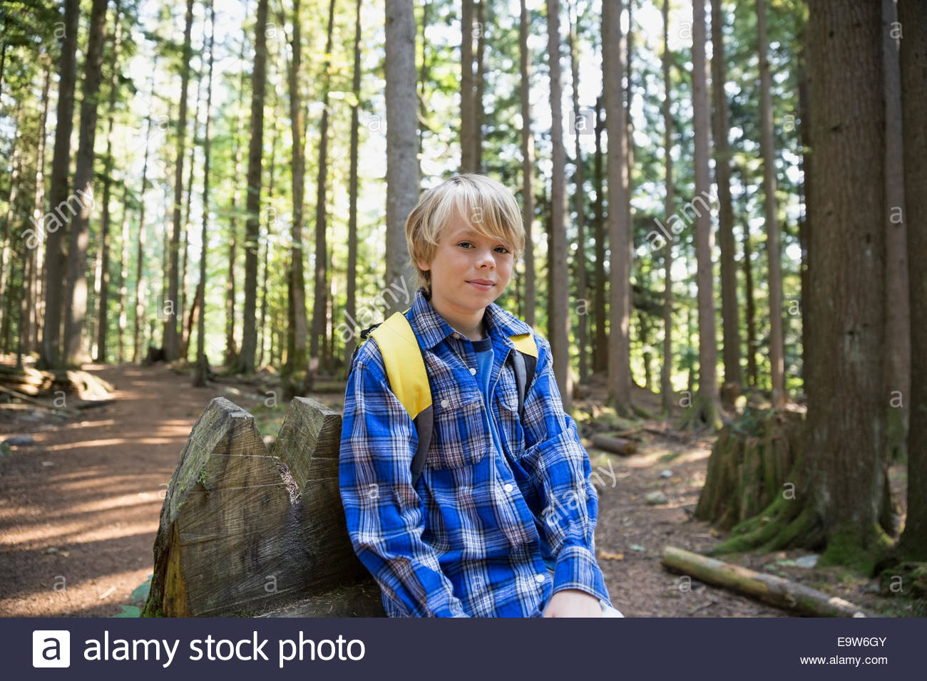 Portrait of boy with backpack in woods Stock Photo