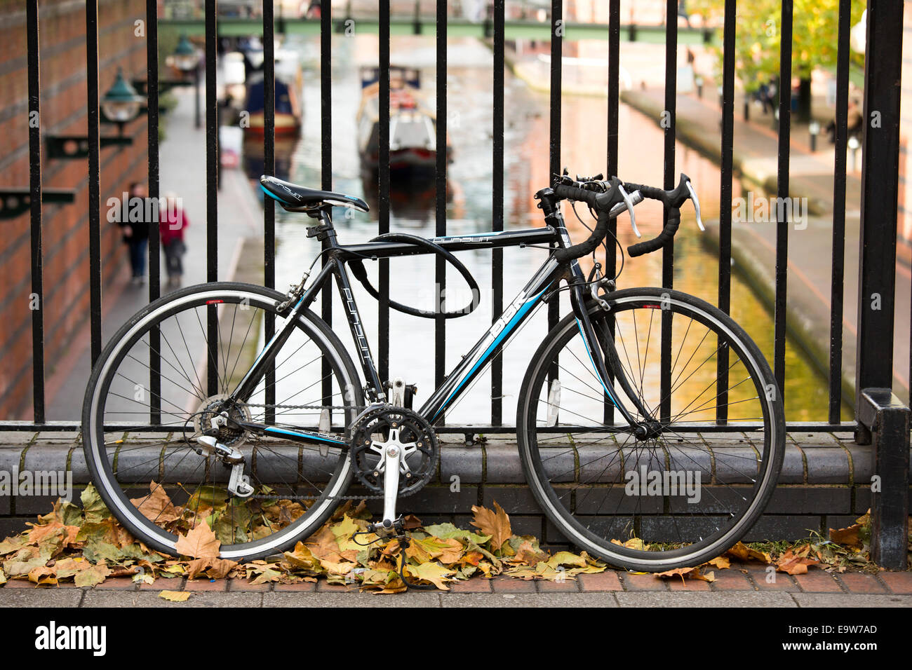 A bicycle chained to railings on Broad Street, Birmingham, overlooking Brindleyplace canal Stock Photo