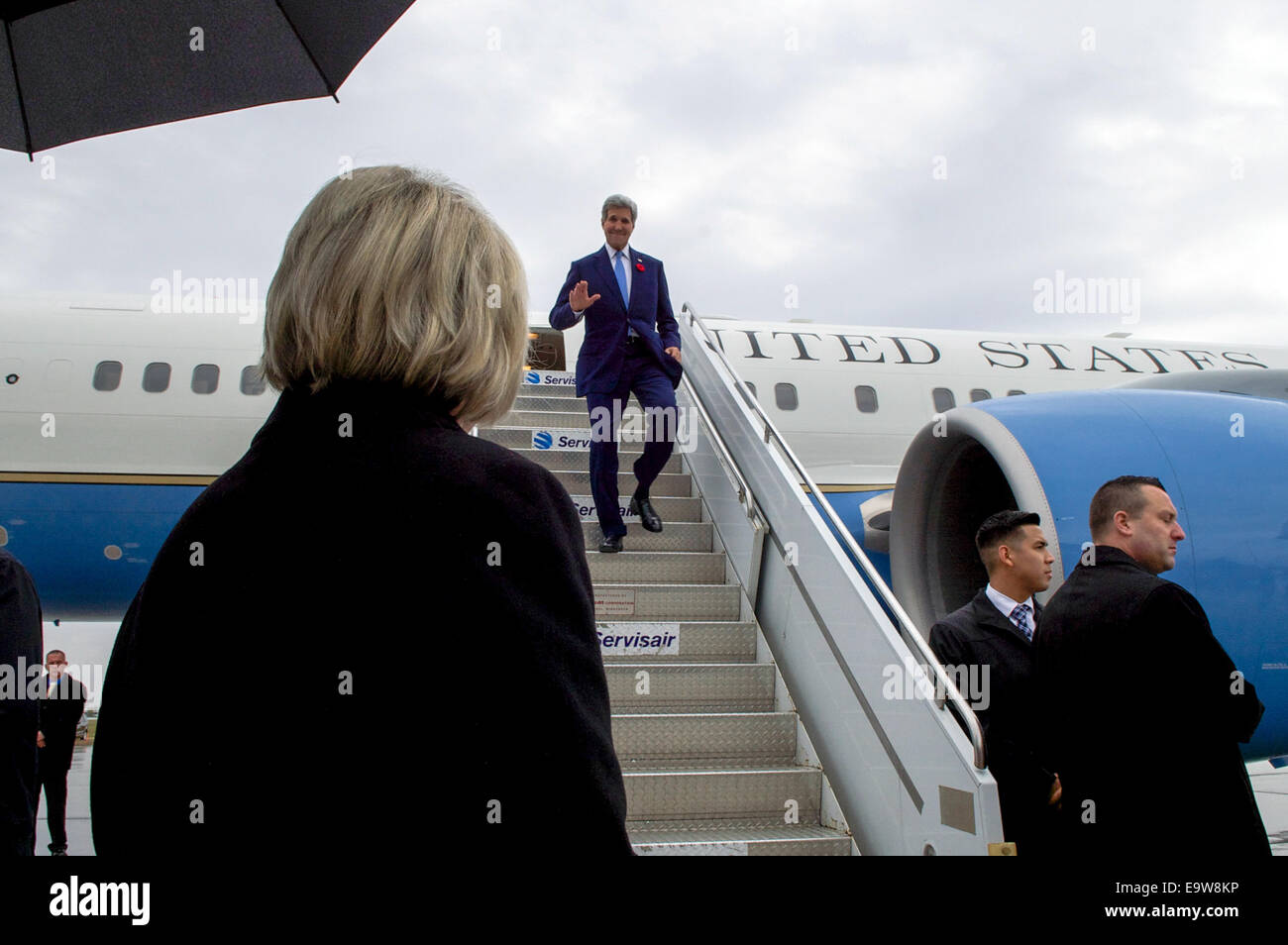 U.S. Secretary of State John Kerry waves to Canadian Minister of State Lynne Yelichas he disembarks from his plane upon arrival Stock Photo