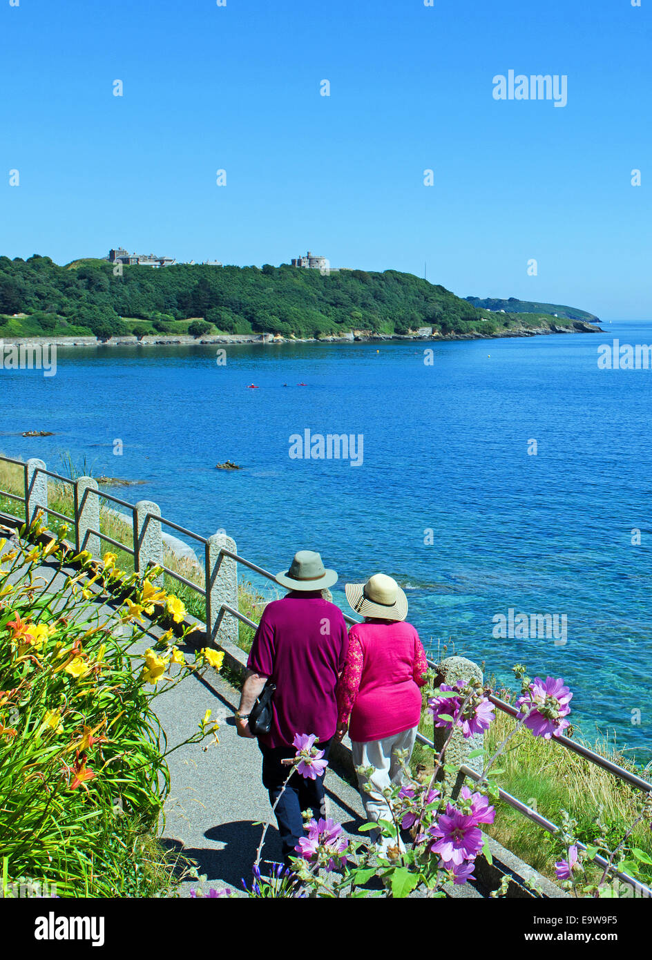 a couple walking along the seafront at Falmouth in Cornwall, UK Stock Photo