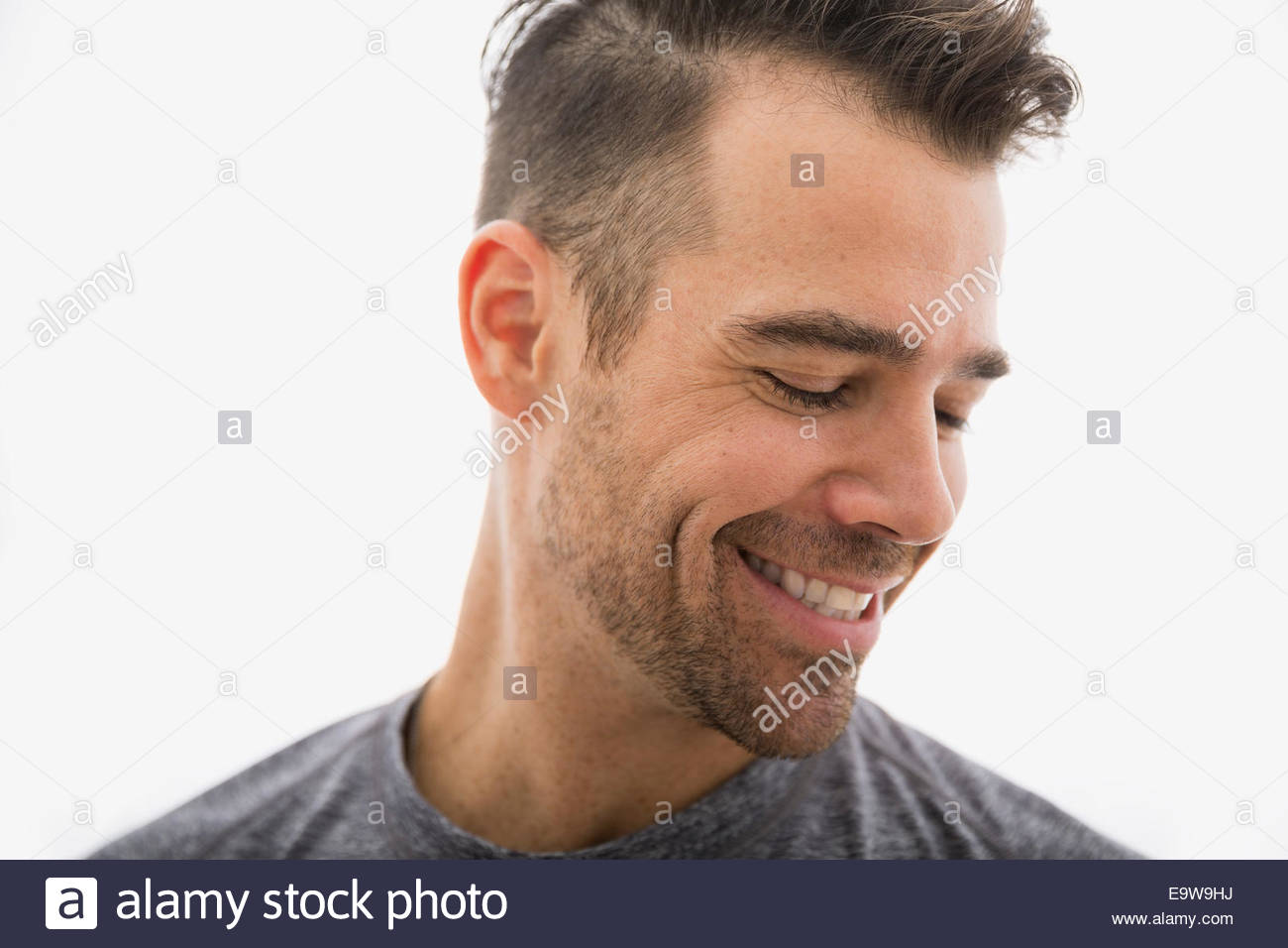 Close up of smiling brunette man looking down Stock Photo