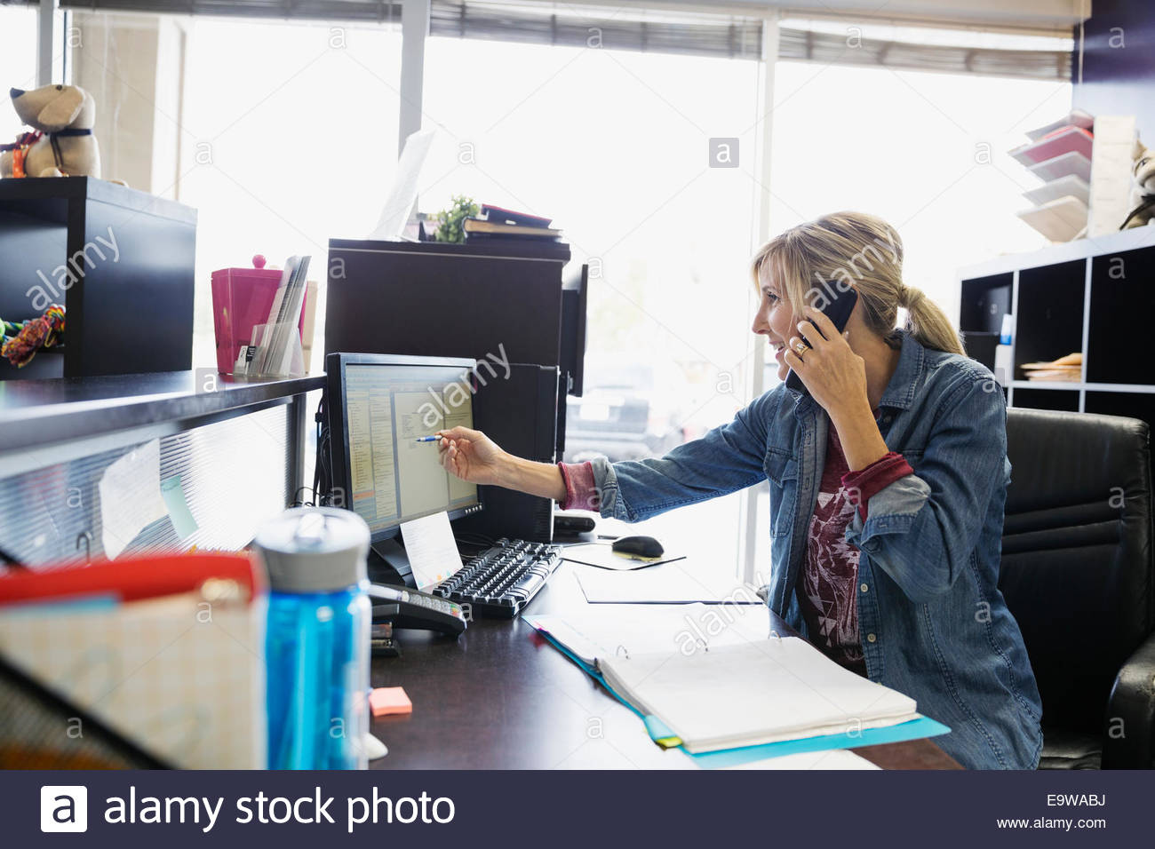 Dog daycare owner scheduling appointment at desk Stock Photo