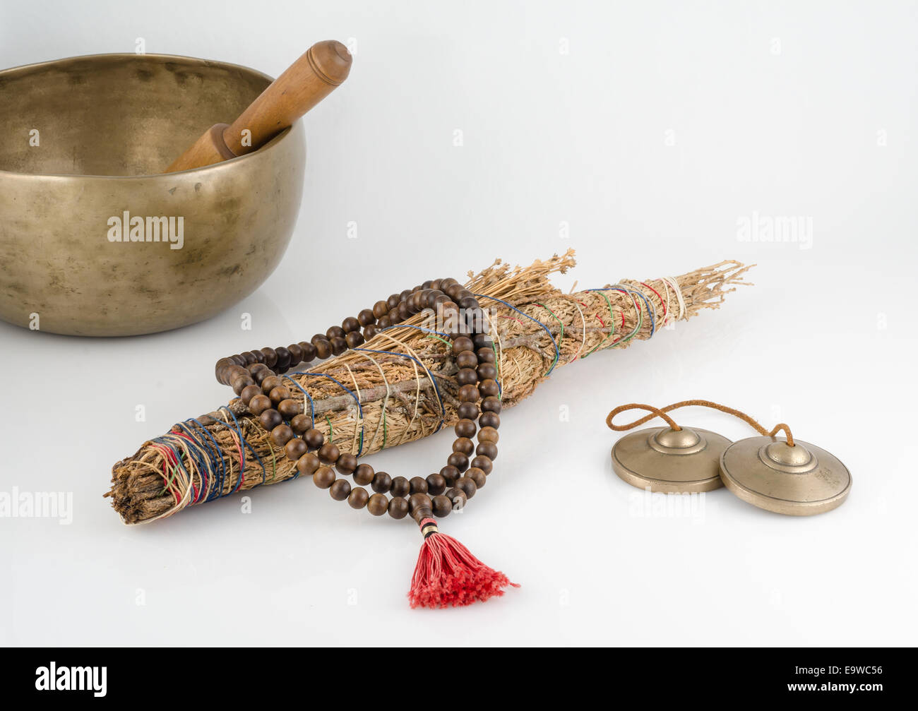Hand Made Singing Bowl with Ringing Stick, Prayer Beads, Meditation Bells and Smudge Stick. Stock Photo