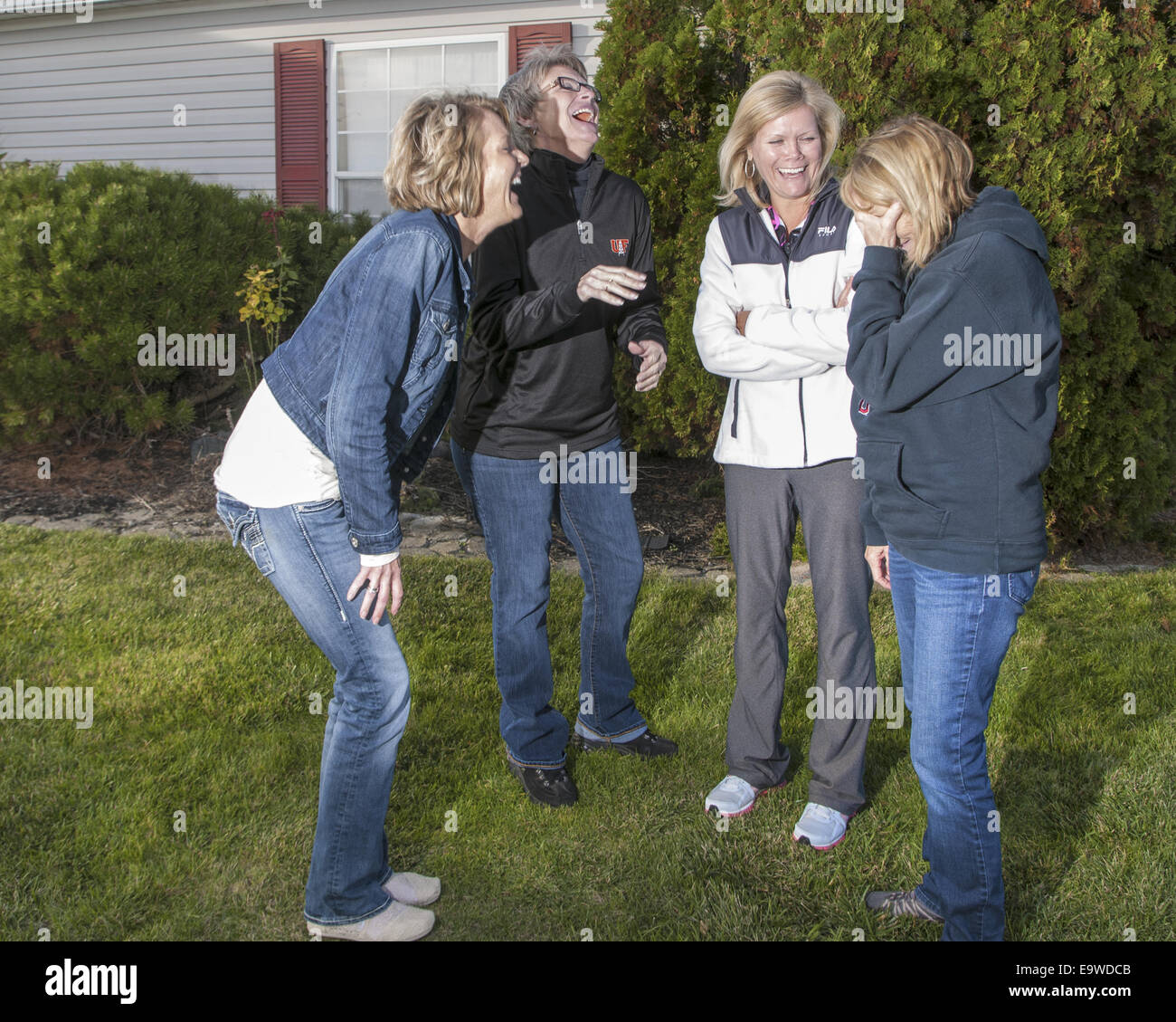 4 mature women standing outside laughing. Stock Photo