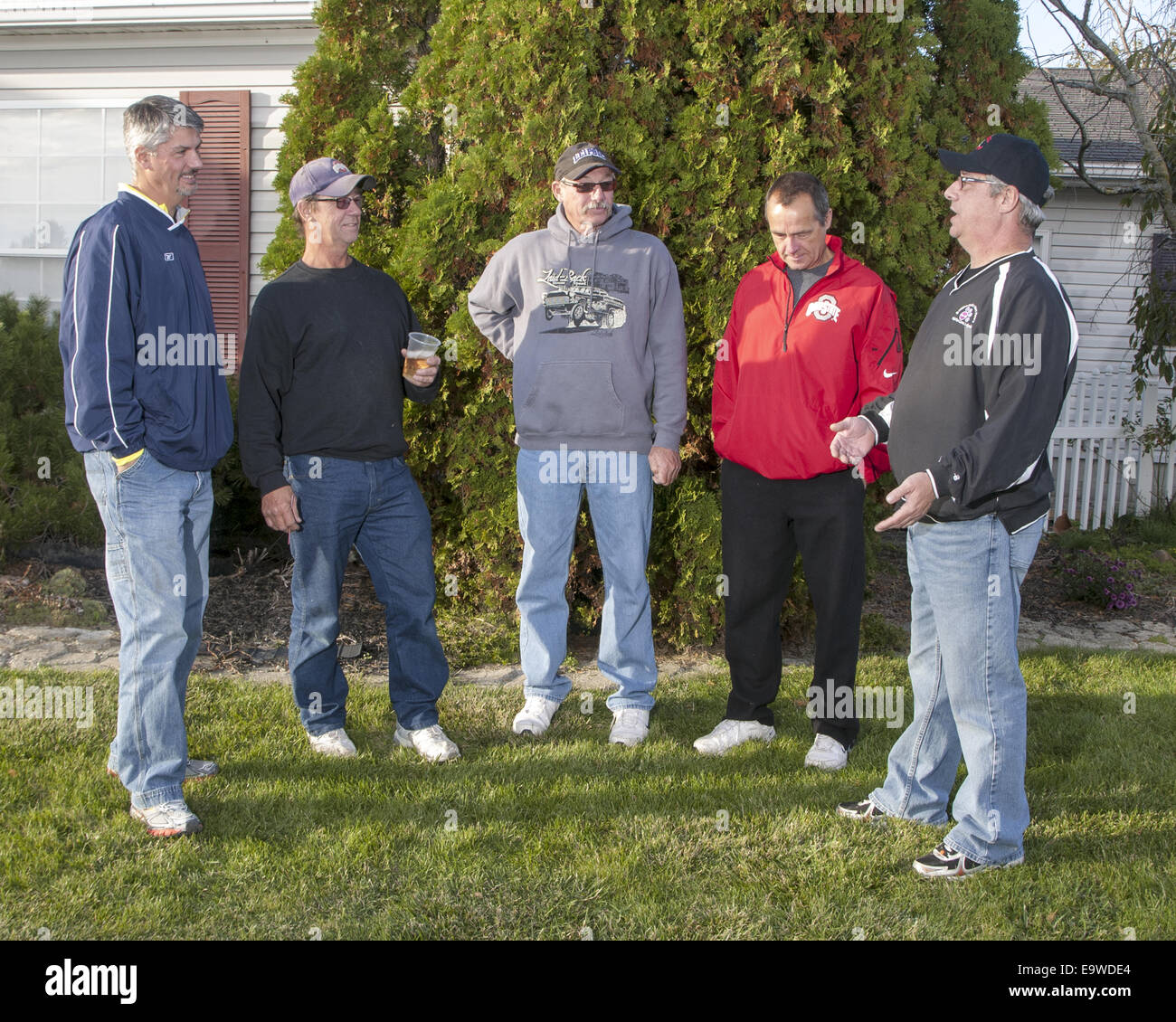 5-men-are-standing-outside-in-a-half-circle-one-is-talking-and-the-E9WDE4.jpg