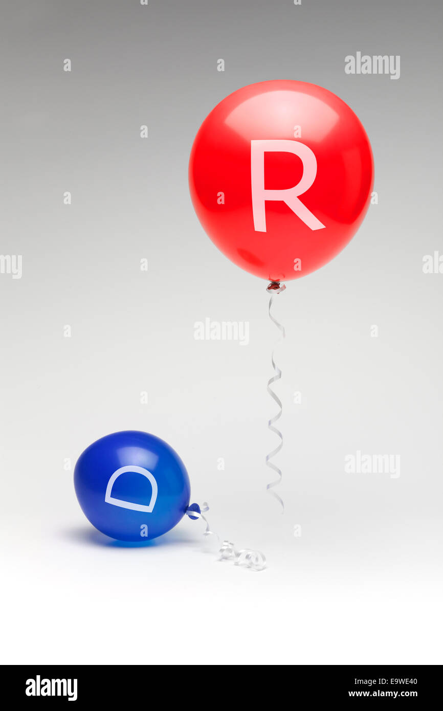 A red republican balloon floating over a partially deflated blue democratic balloon. Stock Photo
