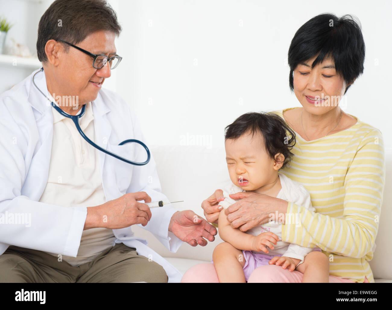 Family doctor vaccines  or injection to baby girl. Pediatrician and patient. Stock Photo