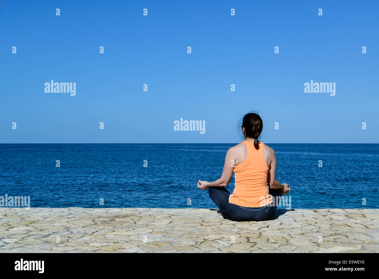 Woman practicing oceanfront yoga meditation, Jamaica. Stock Photo