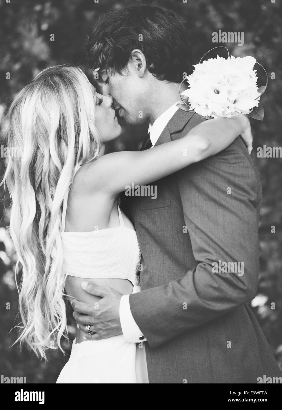 Wedding, Beautiful Romantic Bride and Groom Kissing and Embracing at Sunset. Black and White Image. Stock Photo
