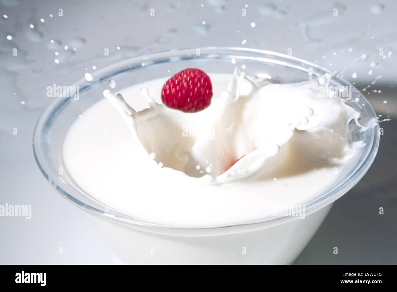 Raspberry drops in a bowl of milk Stock Photo