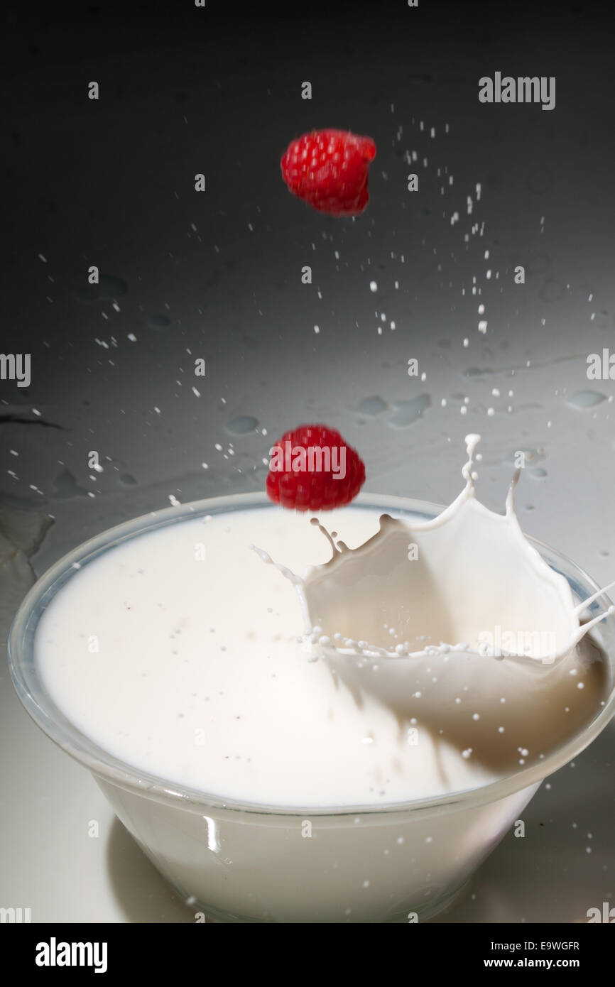Raspberries fall into milk Stock Photo Alamy