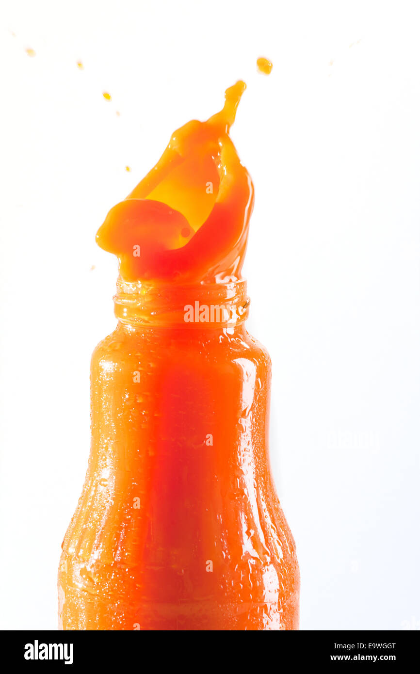 Carrot juice squirts out of the bottle Stock Photo