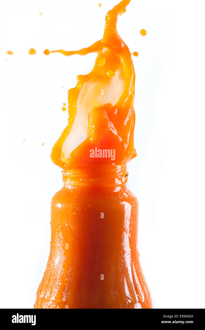 Carrot juice squirts out of the bottle Stock Photo