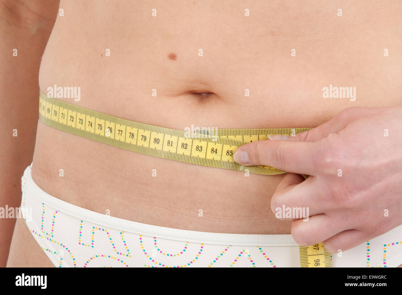 Young woman measuring her abdominal girth Stock Photo - Alamy